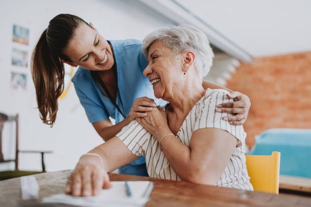 A caregiver sharing a laugh with a senior client at home